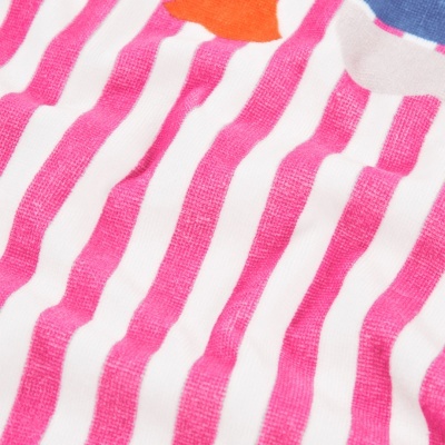 Pano com riscas cor-de-rosa e branco, e fundo colorido azul, laranja e branco