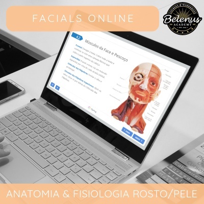 Portátil com estudo anatómico muscular da face, teclado prateado, telemóvel e folheto ao lado