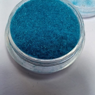 Frasco transparente com fibras azuis finas e tampa aberta