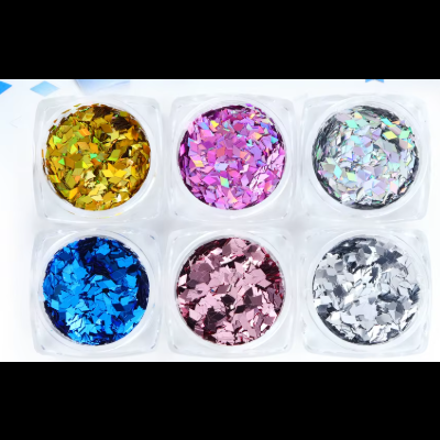 Seis pequenos recipientes com glitter colorido em tons metálicos