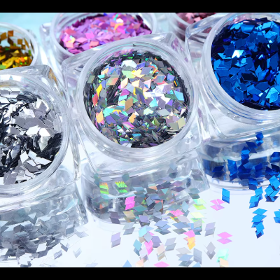 Potes de glitter colorido metálico espalhados numa superfície espelhada