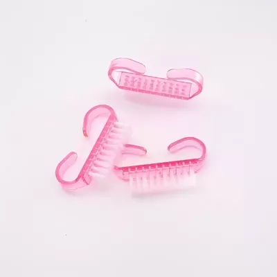 Três pequenas escovas de unhas de plástico cor-de-rosa com cerdas brancas