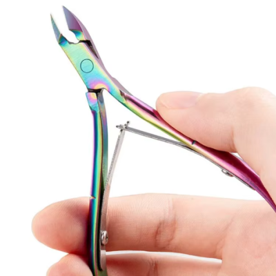 Alicate de cutículas metálico iridescente numa mão