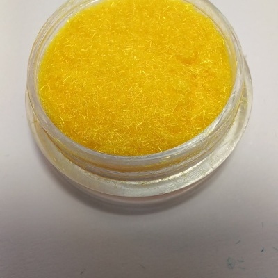 Frasco transparente aberto com fibras amarelas finas no interior sobre fundo branco