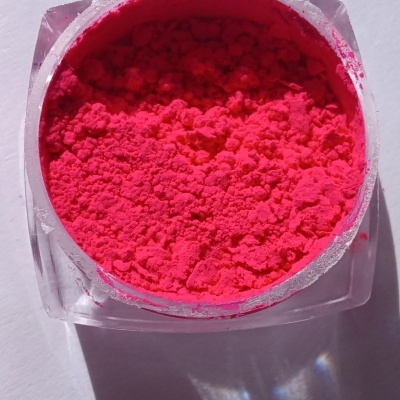 Pó pigmento rosa-choque em embalagem plástica transparente sobre fundo branco