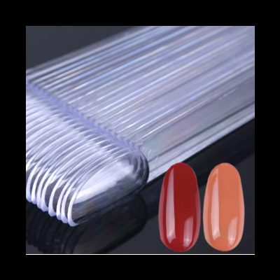 Leque transparente com amostras de unhas artificiais e duas unhas postiças vermelha e cor de pêssego.