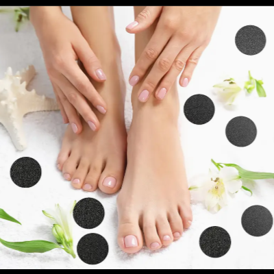 Mãos e pés femininos com unhas pintadas de rosa claro sobre toalha branca, flores brancas e estrela-do-mar ao fundo