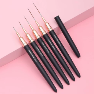 Conjunto de canetas de ponta fina preto e dourado sobre fundo rosa