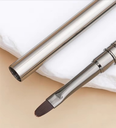 Pincel de maquilhagem com estojo metálico prateado e cerdas escuras