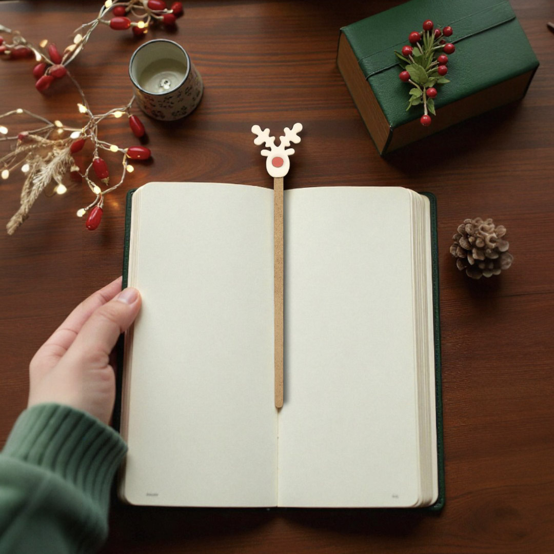 Marcador Rena de Natal Livro aberto com marcador de rena sobre mesa de madeira com decoração natalícia