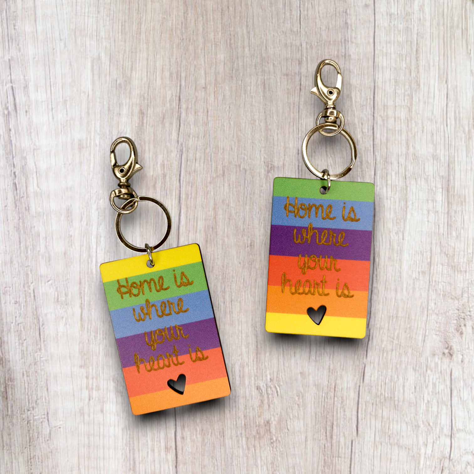 Porta-chaves Home Color Dois porta-chaves com placa colorida em listas horizontais e texto dourado Home is where your heart is