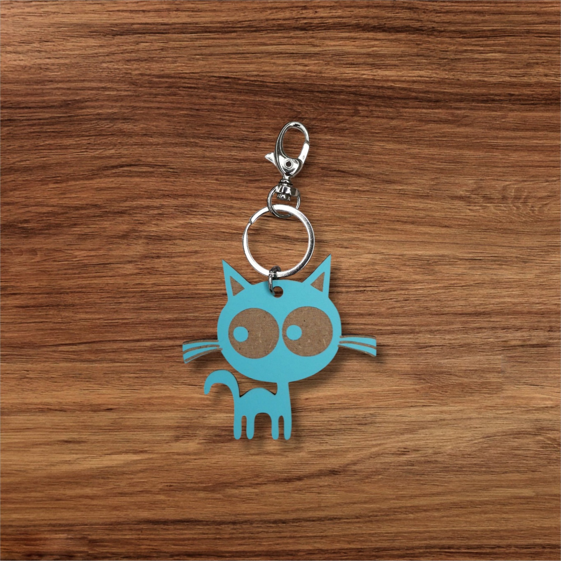 Porta-chaves Sr. Gato Porta-chaves em forma de gato azul com olhos castanhos sobre madeira
