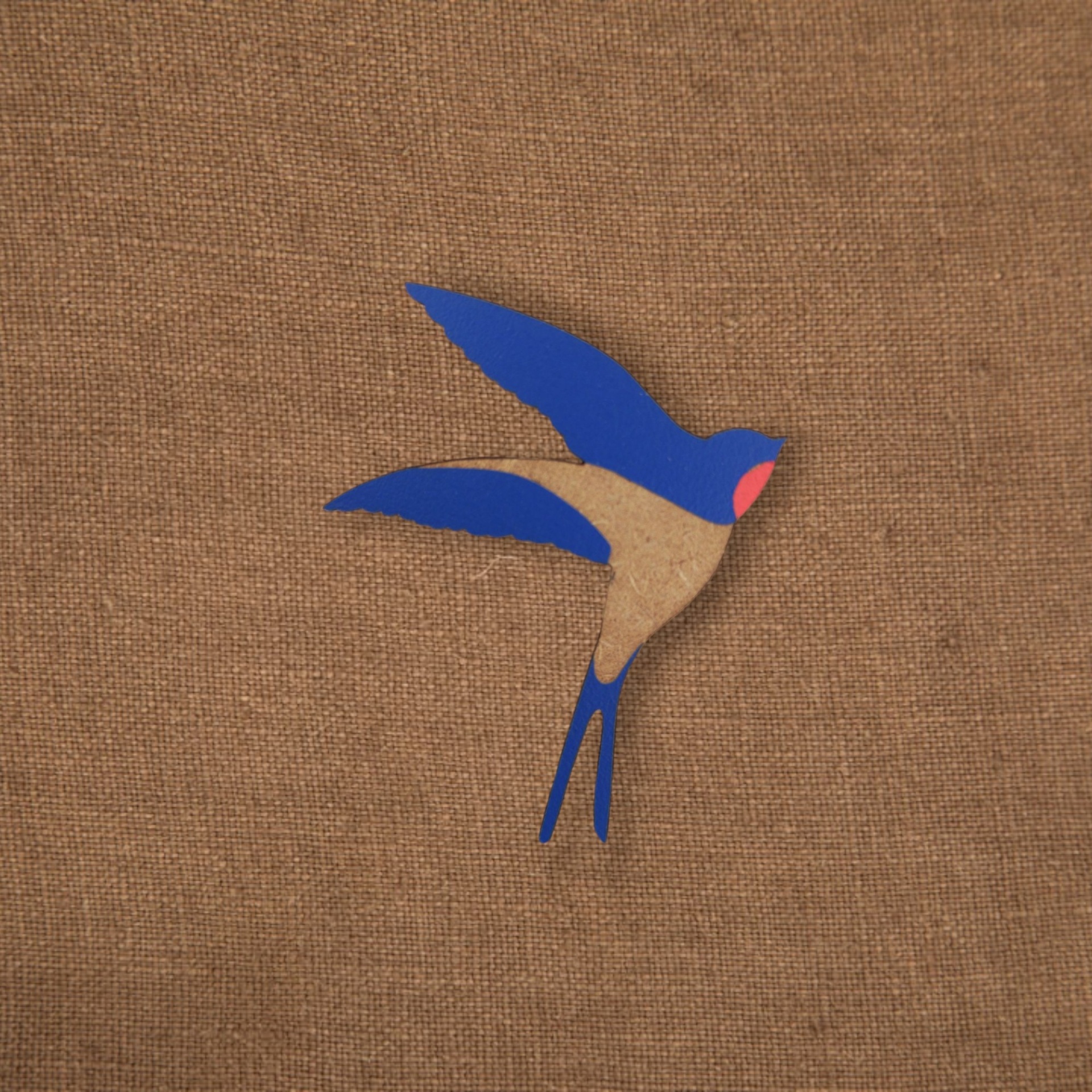 Pregadeira Andorinha Clip pássaro azul e bege sobre tecido castanho