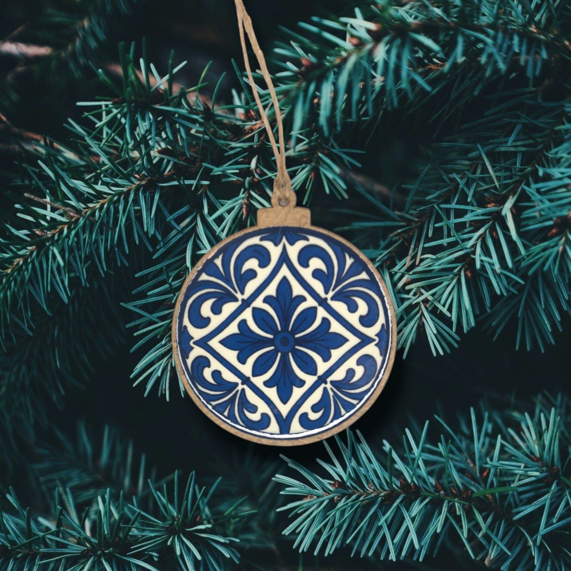 Bola de Natal Flor de Lis Enfeite de Natal redondo em madeira com padrão azul e branco pendurado em ramo de árvore