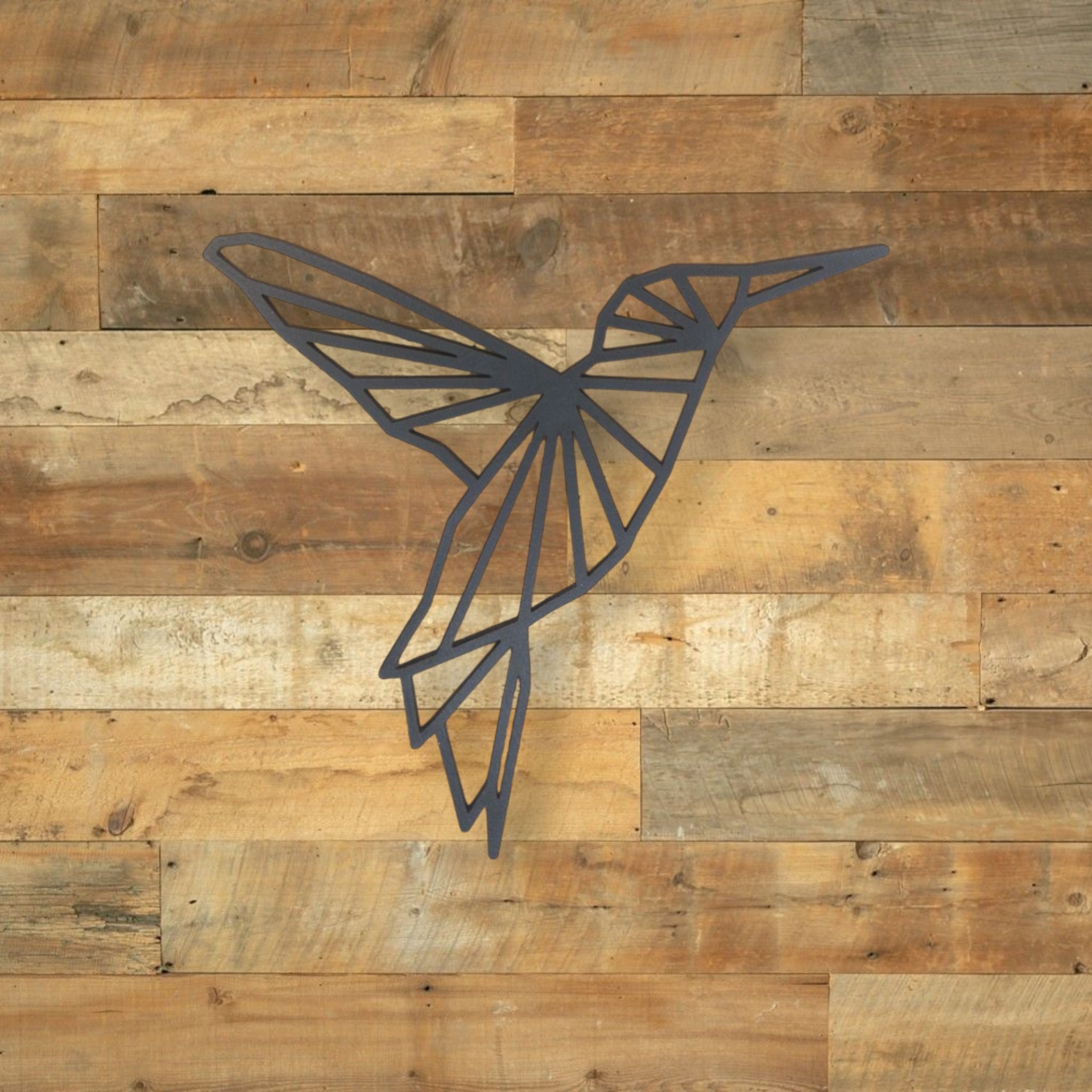 Beija-Flor Origami Escultura de metal preto em forma de beija-flor geométrico numa parede de madeira