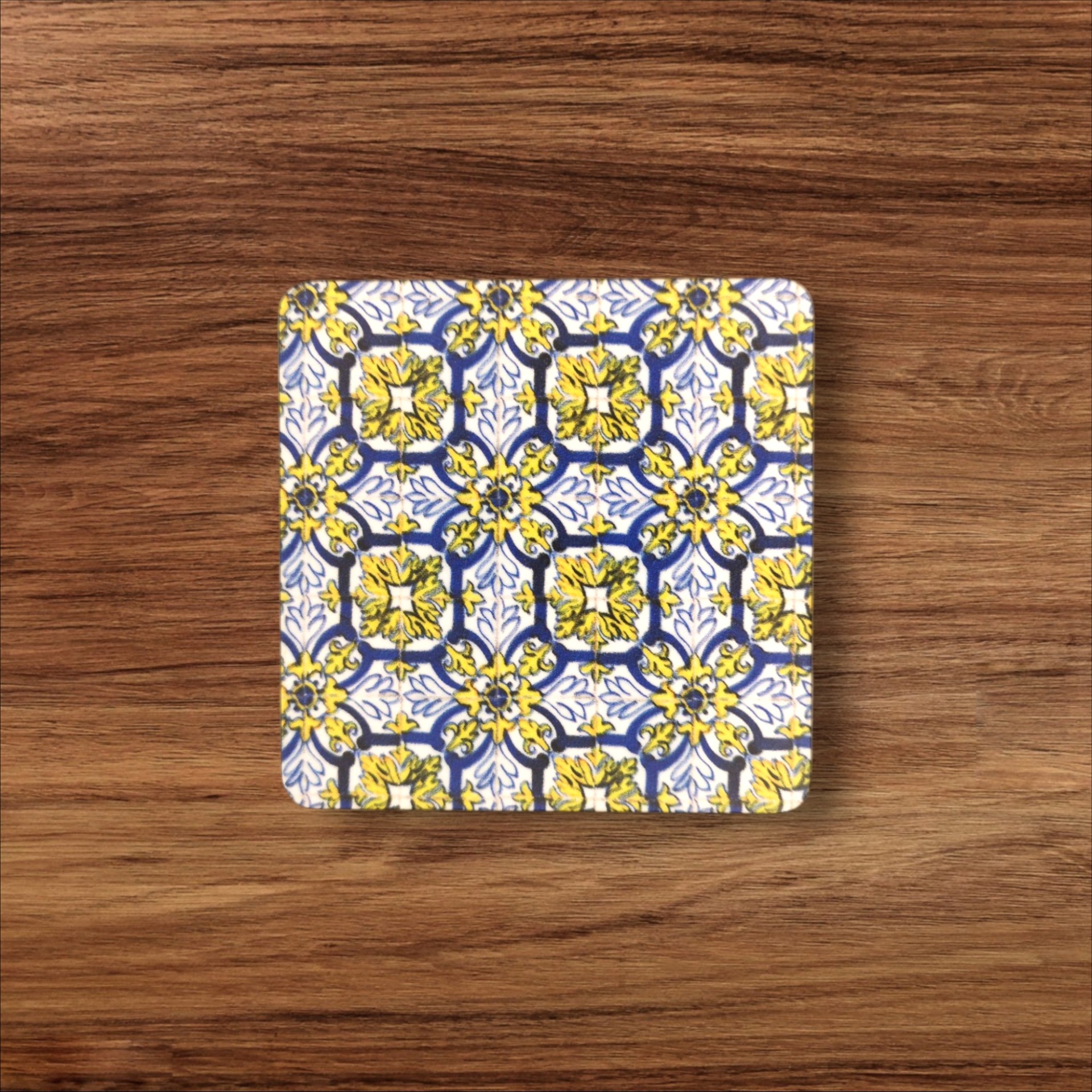 Base de Copos Azulejo Prato quadrado em cerâmica com padrão geométrico colorido sobre mesa de madeira