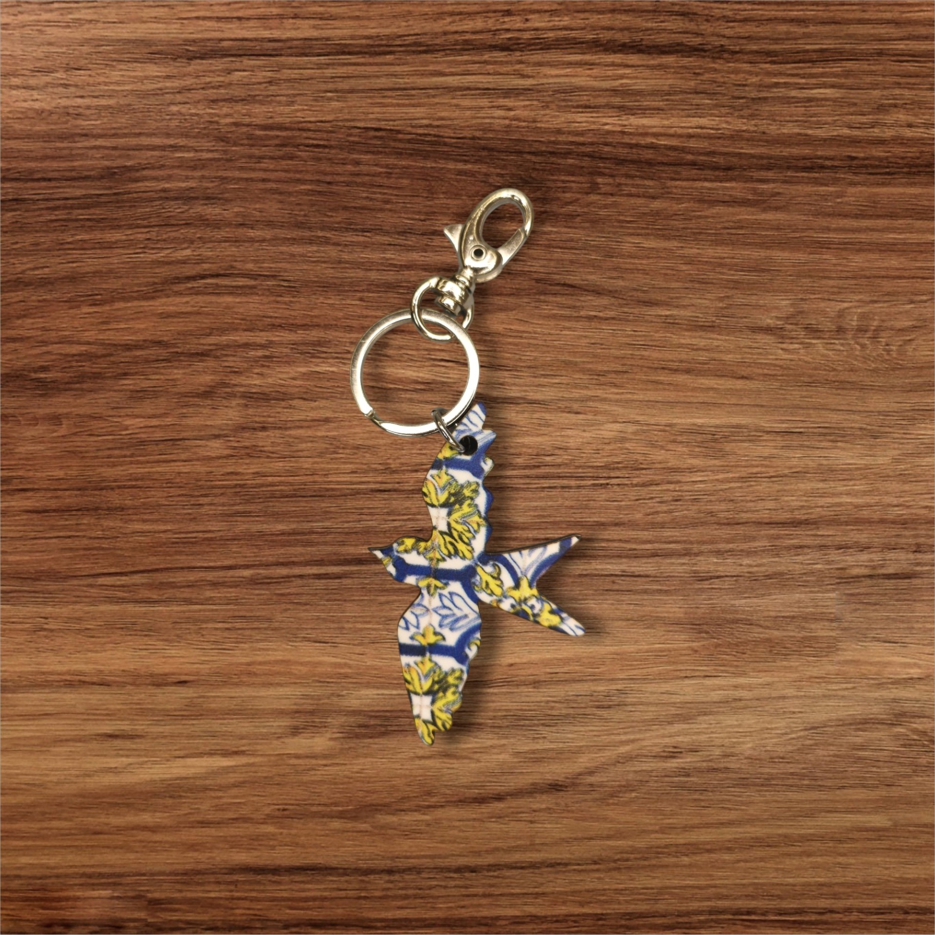 Porta-chaves Andorinha Chaveiro com pendente em forma de pássaro com padrão floral colorido sobre madeira