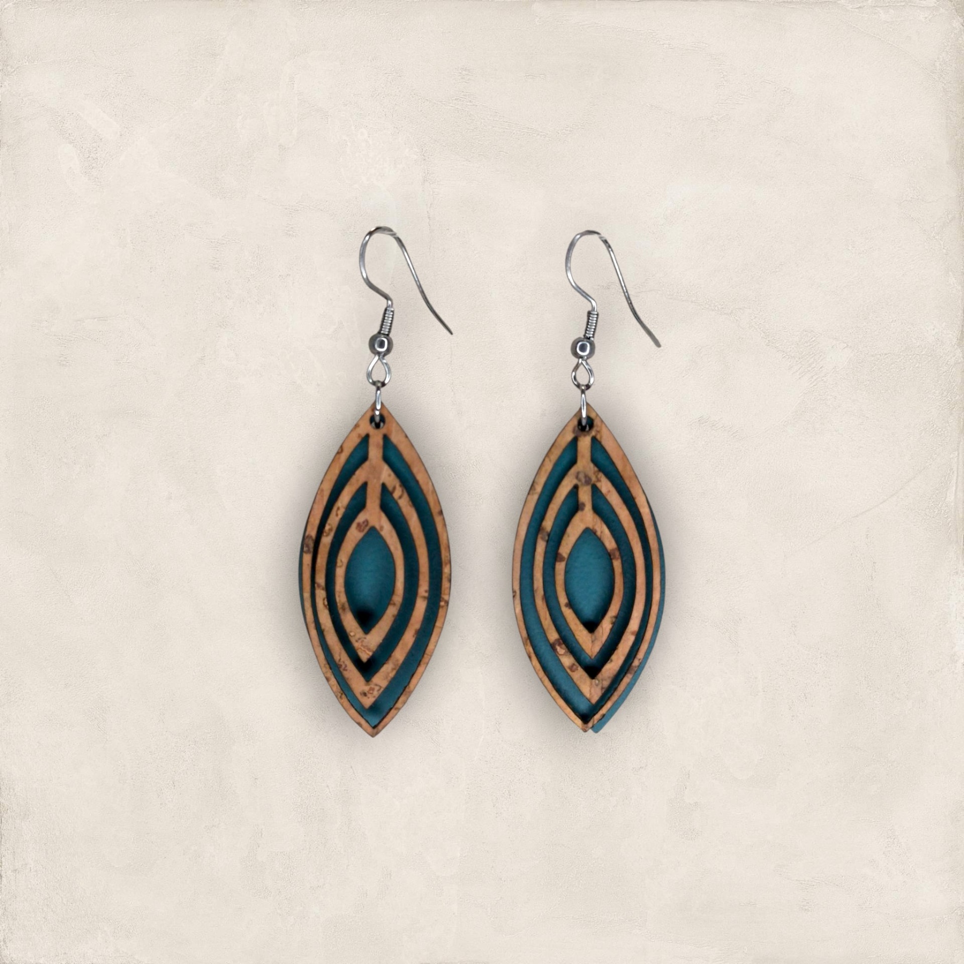 Brincos Gota com Cortiça Brincos pendentes em tons castanho claro e azul-petróleo com ganchos metálicos.