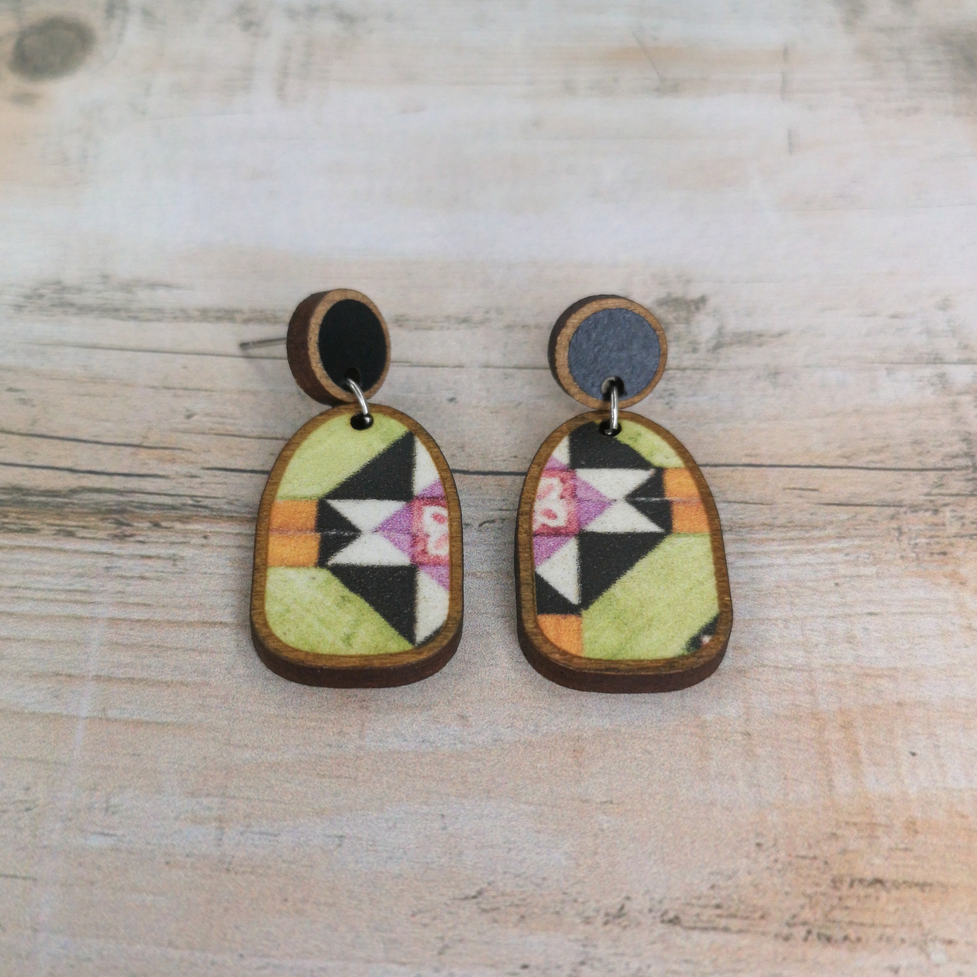 Brincos Boho Brincos de madeira com padrão geométrico colorido em fundo de madeira clara