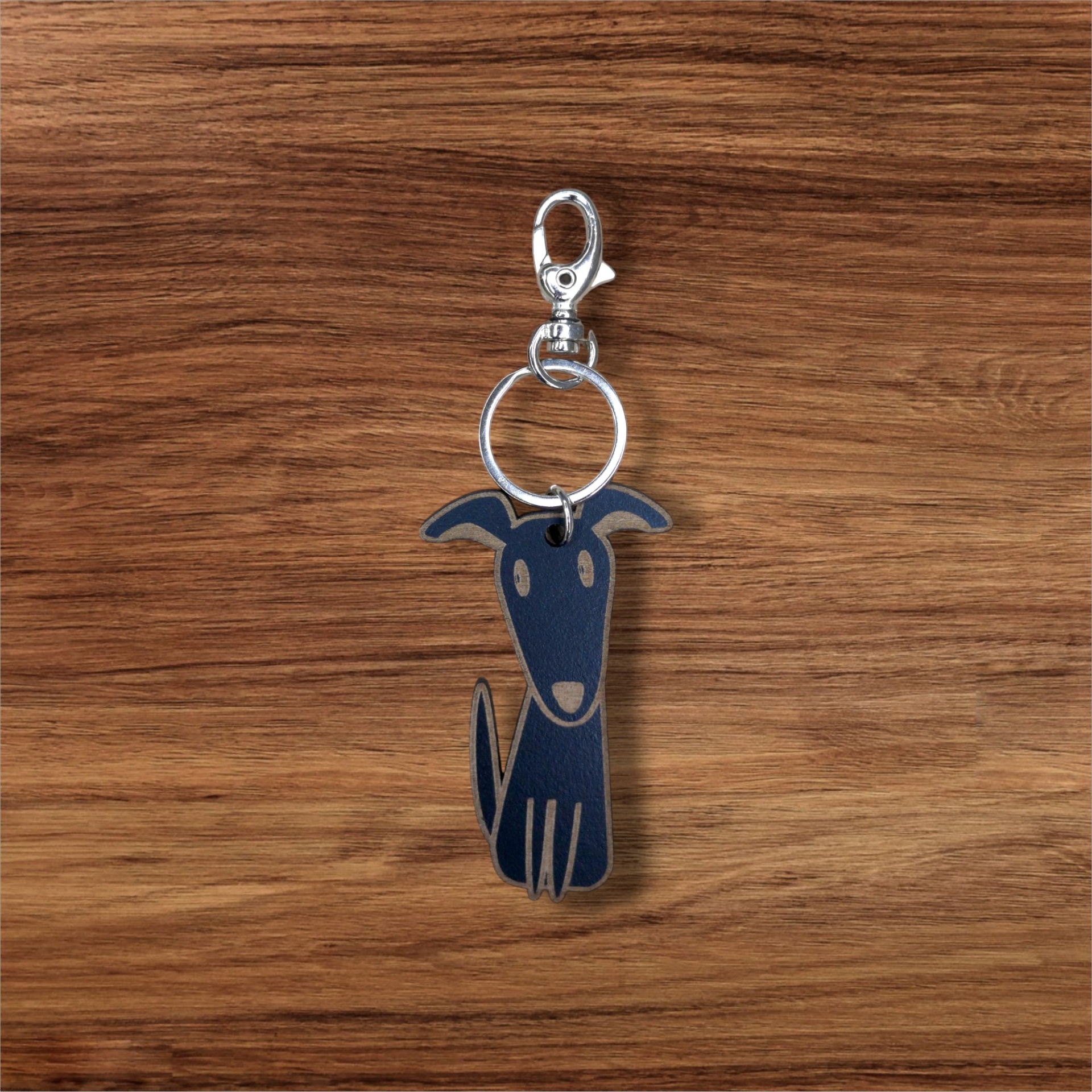 Porta-chaves Cão Chaveiro em formato de cão azul escuro e bege sobre madeira
