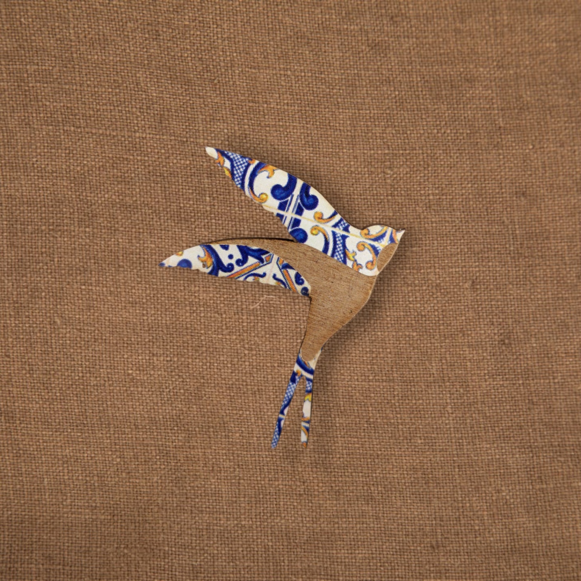 Pregadeira Andorinha Azulejo Pássaro de madeira com padrão azulejo português sobre tecido de juta castanho