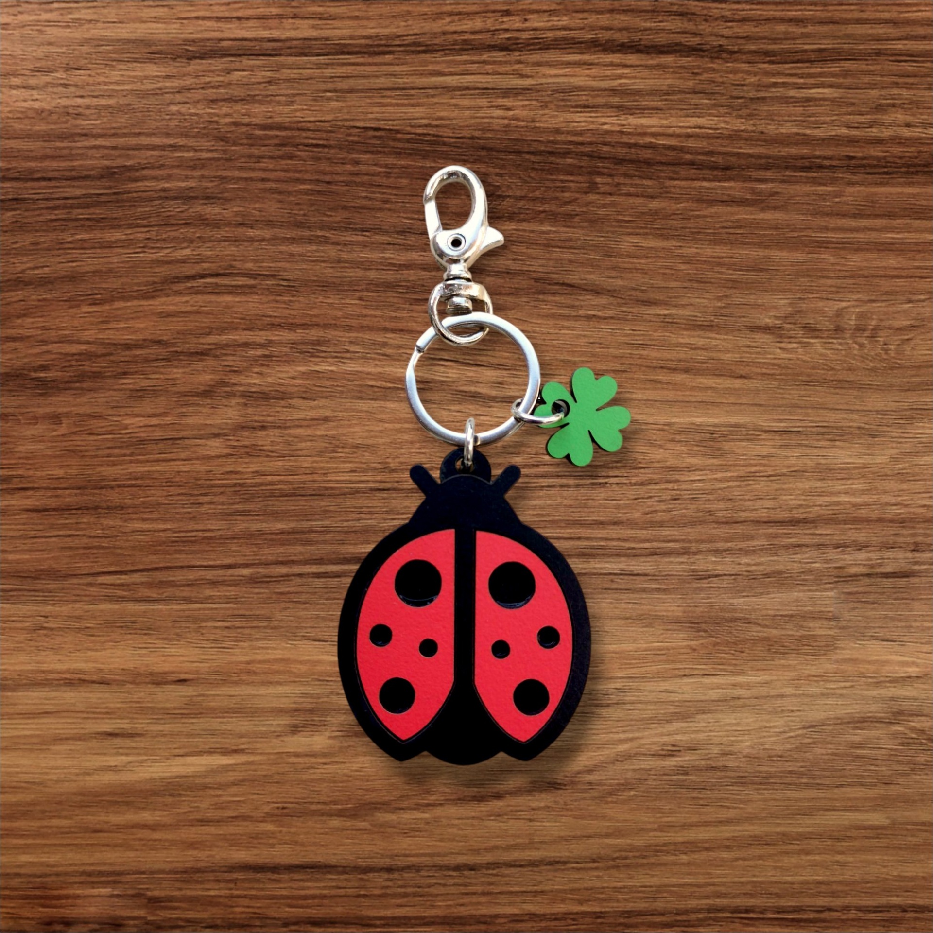 Porta-chaves Joaninha Chaveiro de joaninha vermelho e preto com trevo verde em superfície de madeira