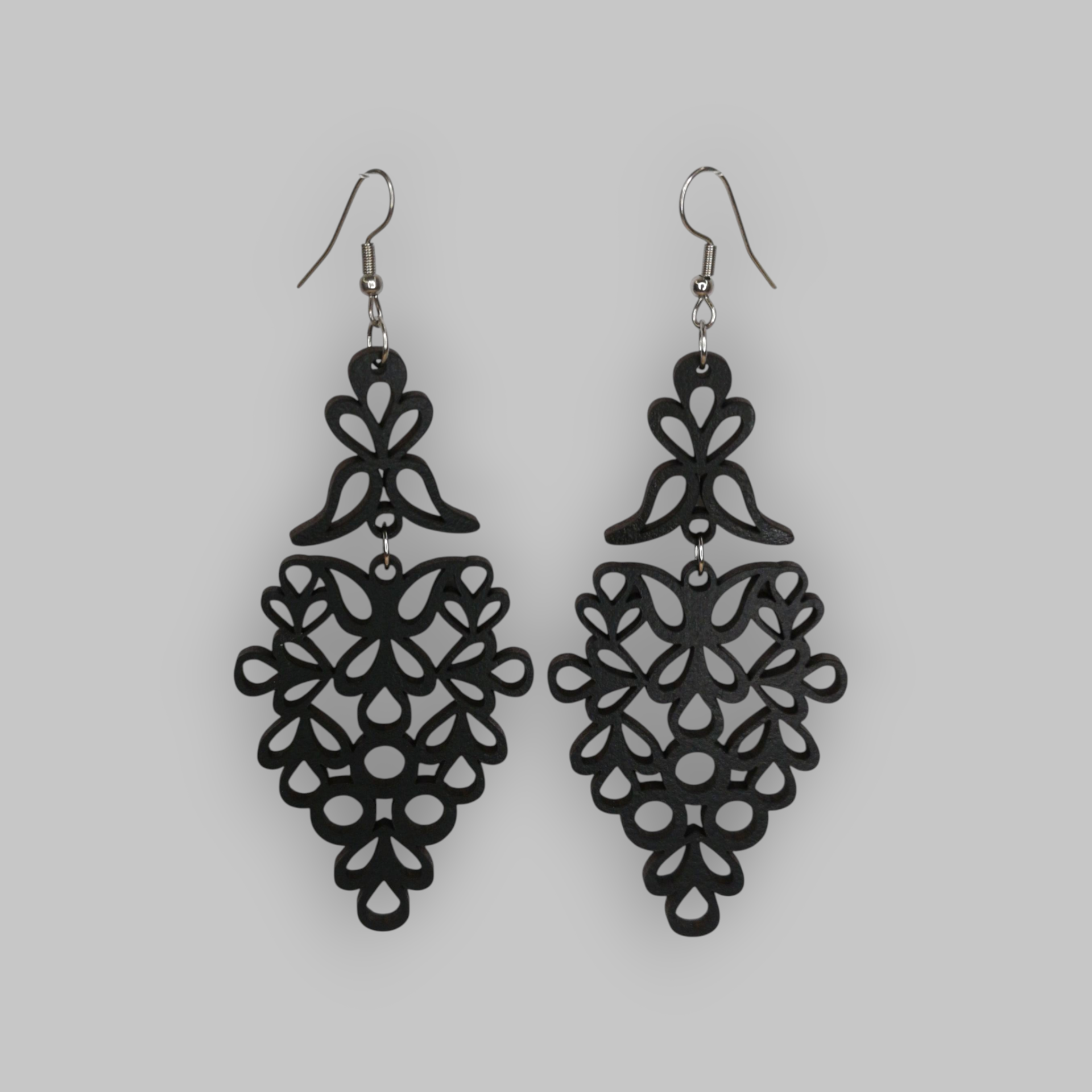 Brincos Vindima Brincos pretos pendentes com padrão floral sobre fundo cinza