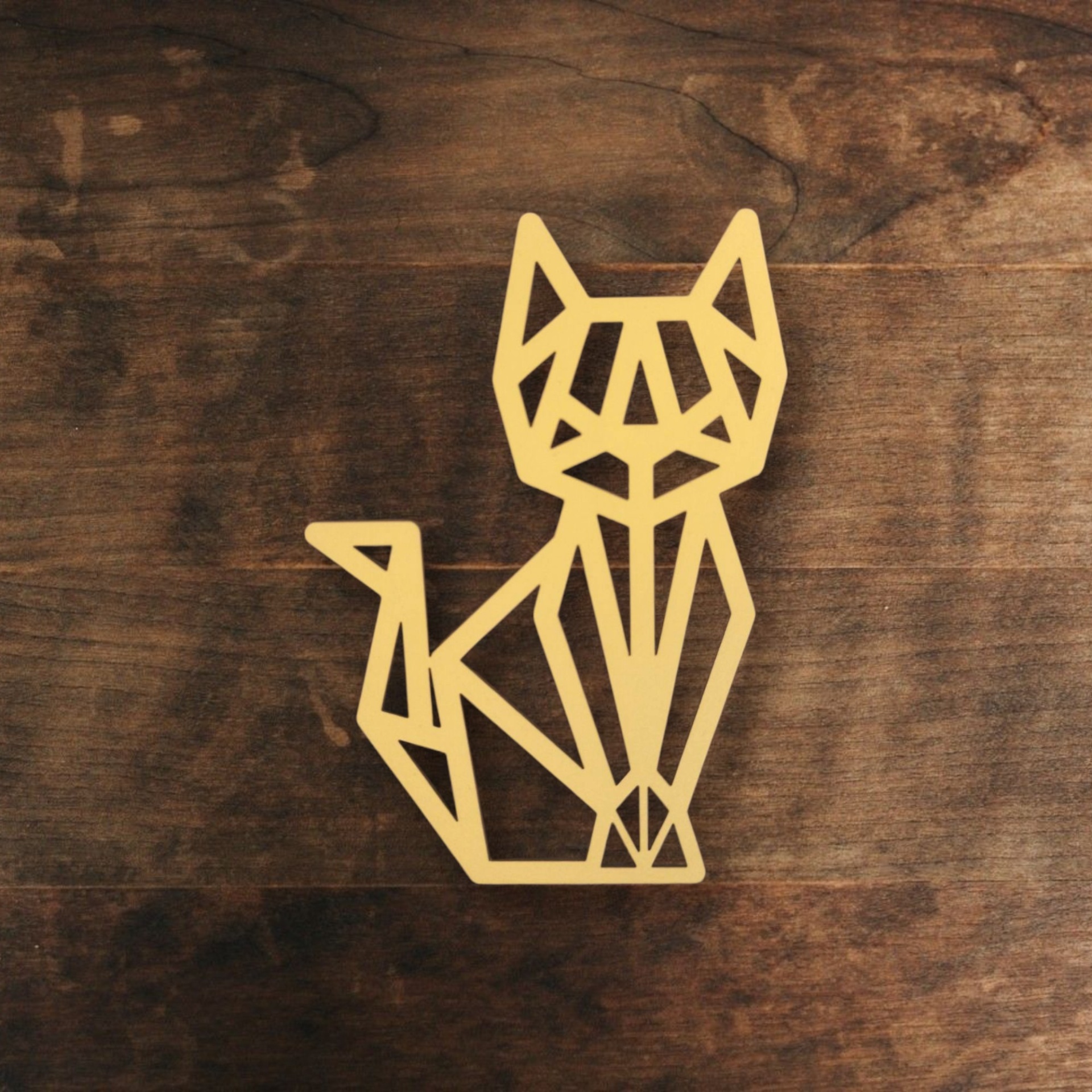 Gato Origami Escultura dourada de gato geométrico sobre madeira escura