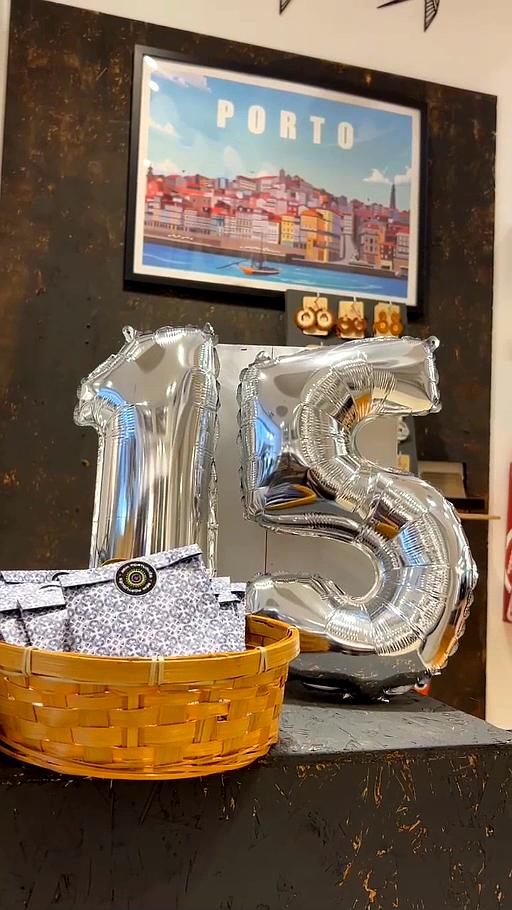 Balões prateados de número 15 em ambiente com cesto e quadro do Porto