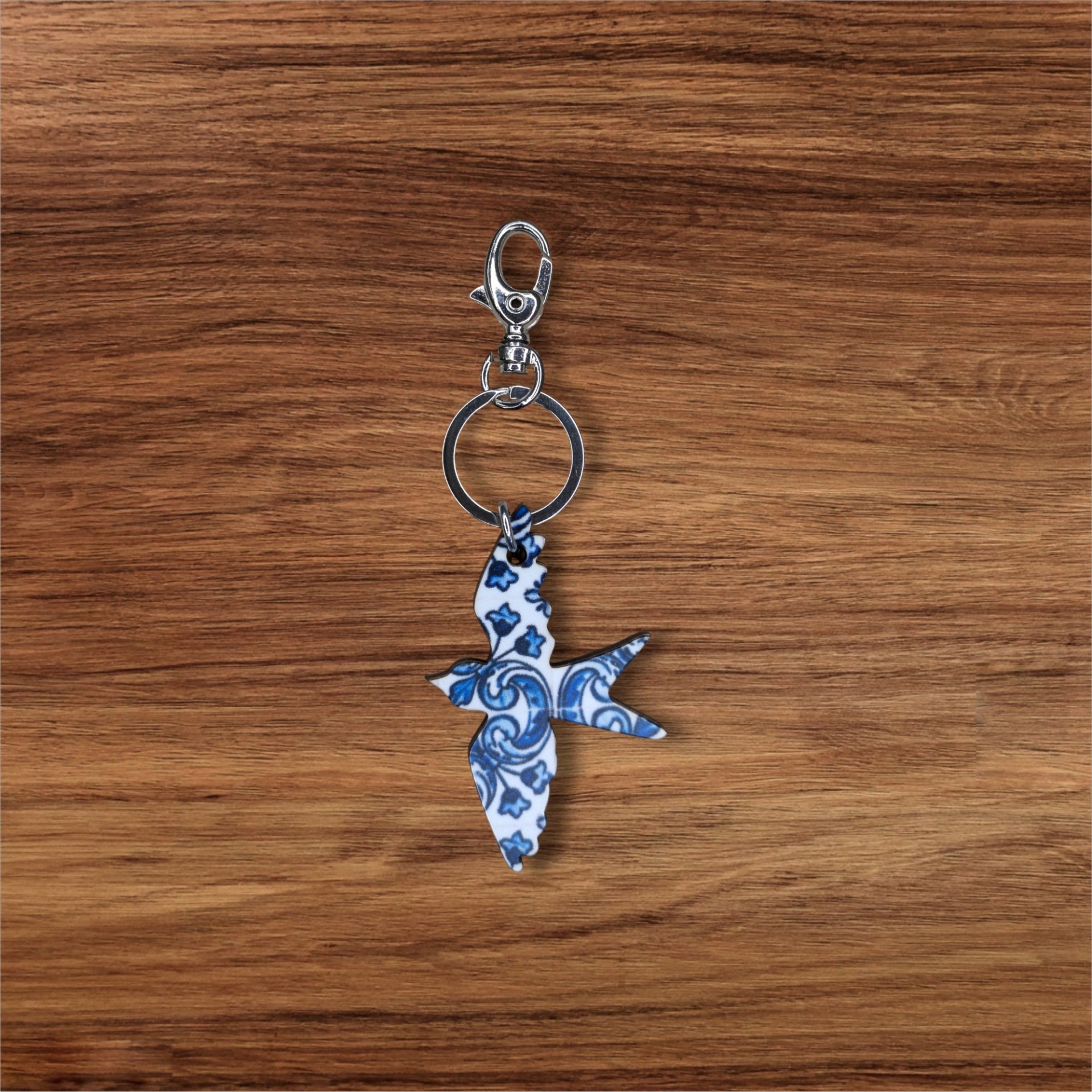 Porta-chaves Andorinha Chaveiro de pássaro em metal com padrão azul e branco sobre madeira