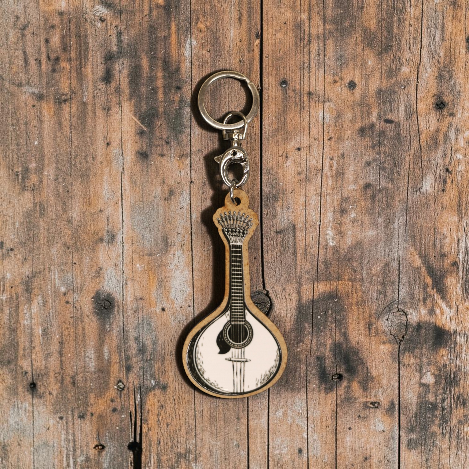 Porta-chaves Guitarra Portuguesa Chaveiro em forma de guitarra portuguesa de madeira e metal sobre fundo de madeira