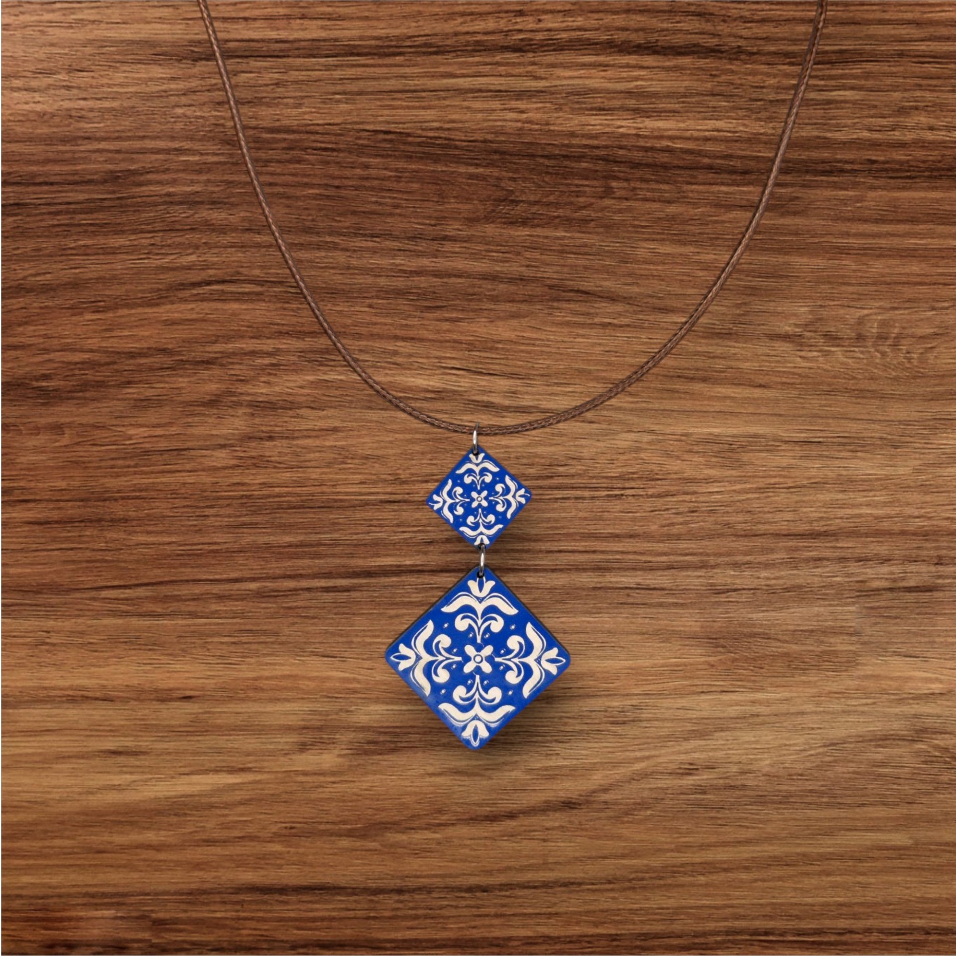 Colar Azulejo Pintado Colar com pendentes quadrados azul e branco com padrão floral em fundo de madeira