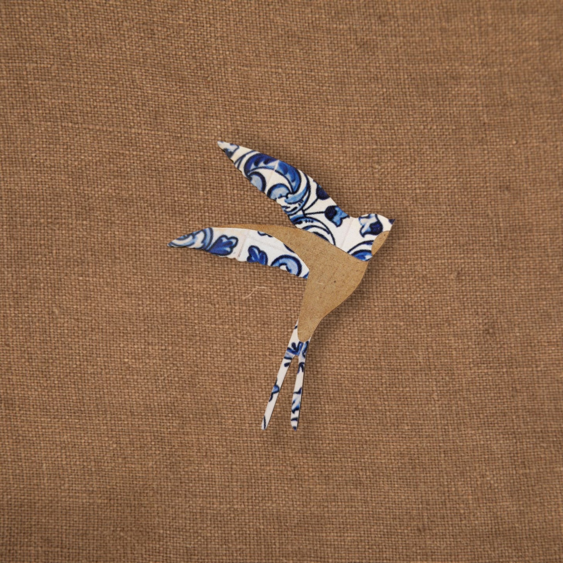 Pregadeira Andorinha Azulejo Aplicação decorativa de pássaro em papel azul e castanho sobre tecido castanho