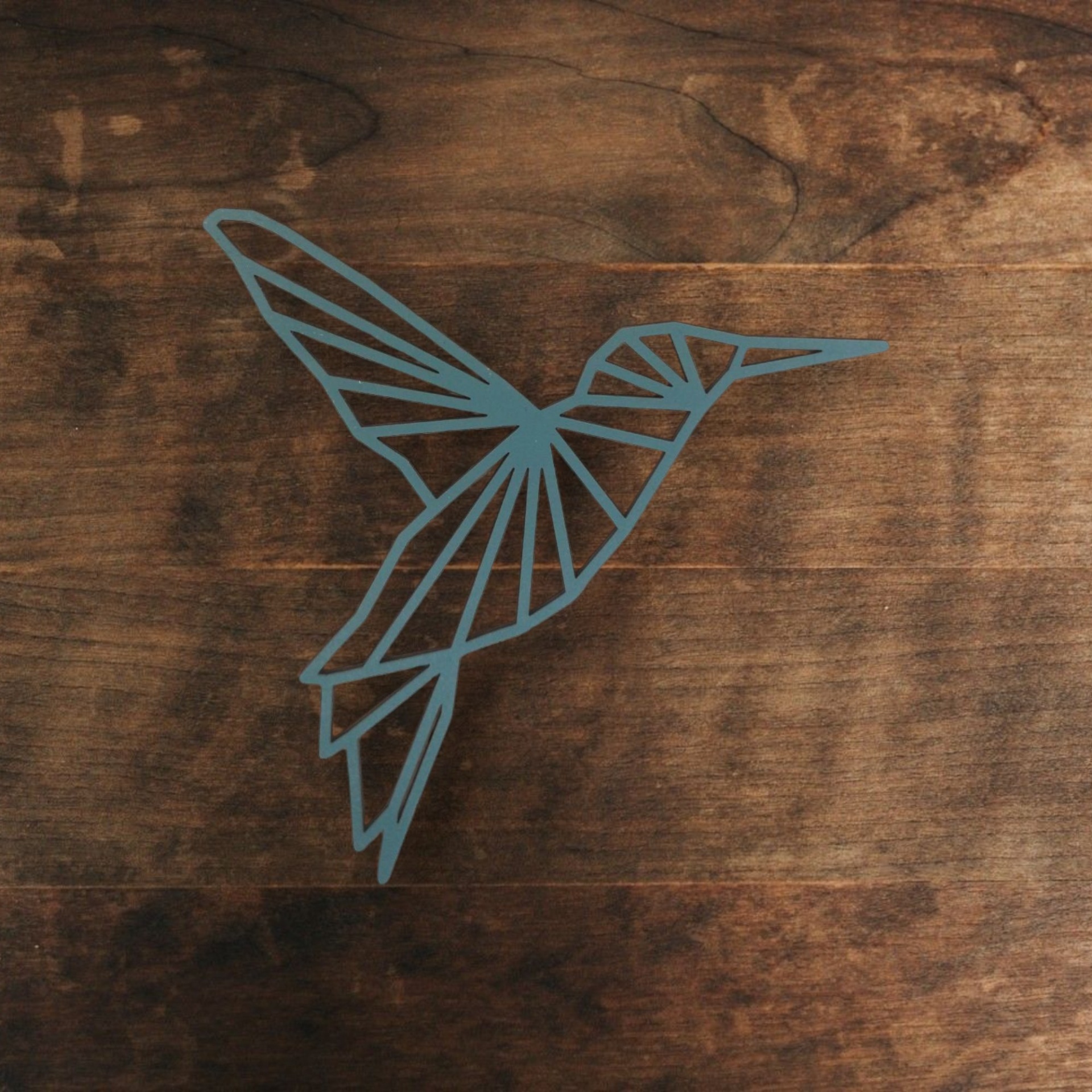 Beija-Flor Origami Desenho geométrico de um beija-flor azul numa superfície de madeira
