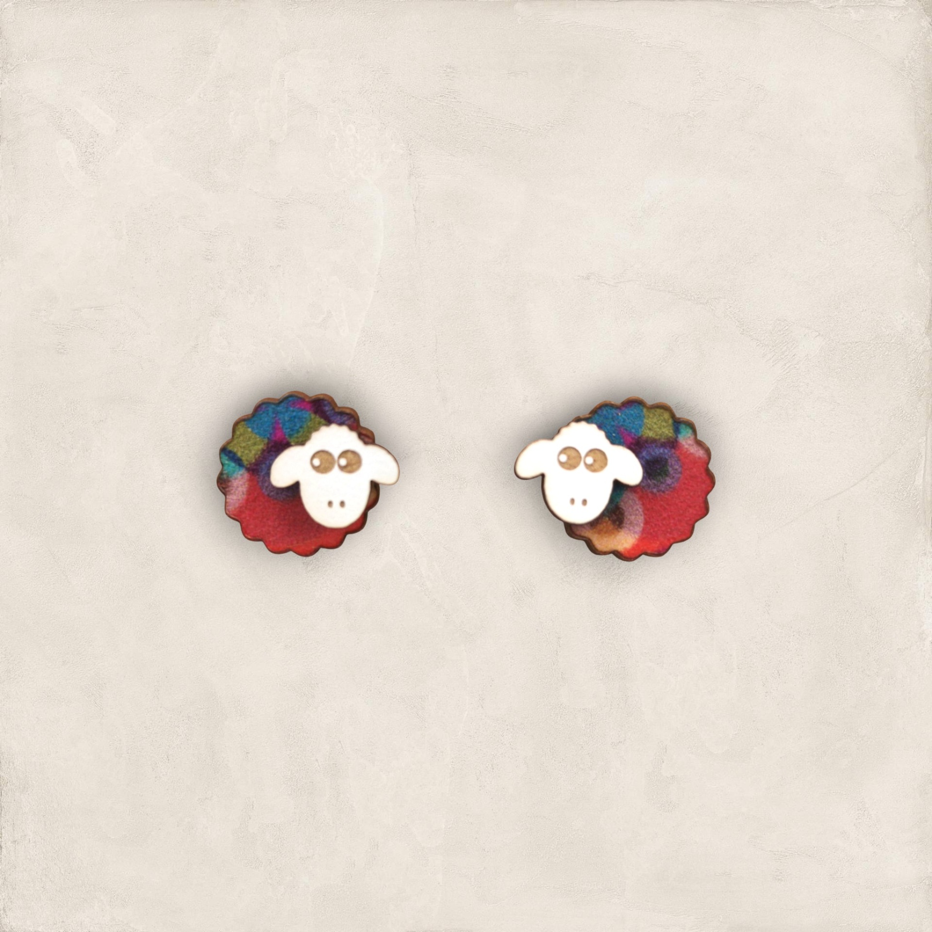 Brincos Ovelhinha Botões decorativos em forma de ovelha colorida sobre fundo cinza claro