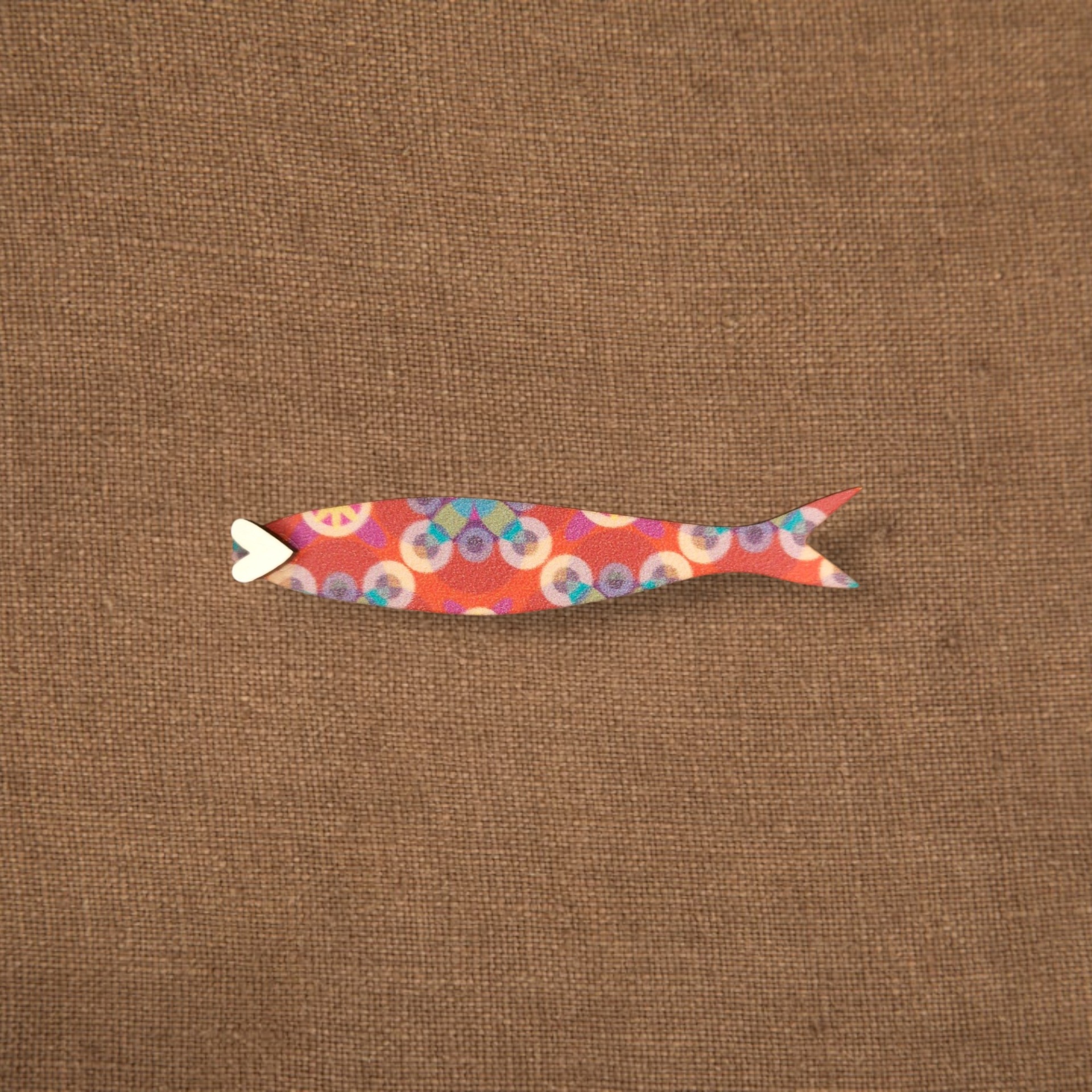 Pregadeira Sardinha Azulejo Figura decorativa colorida em forma de peixe sobre tecido castanho