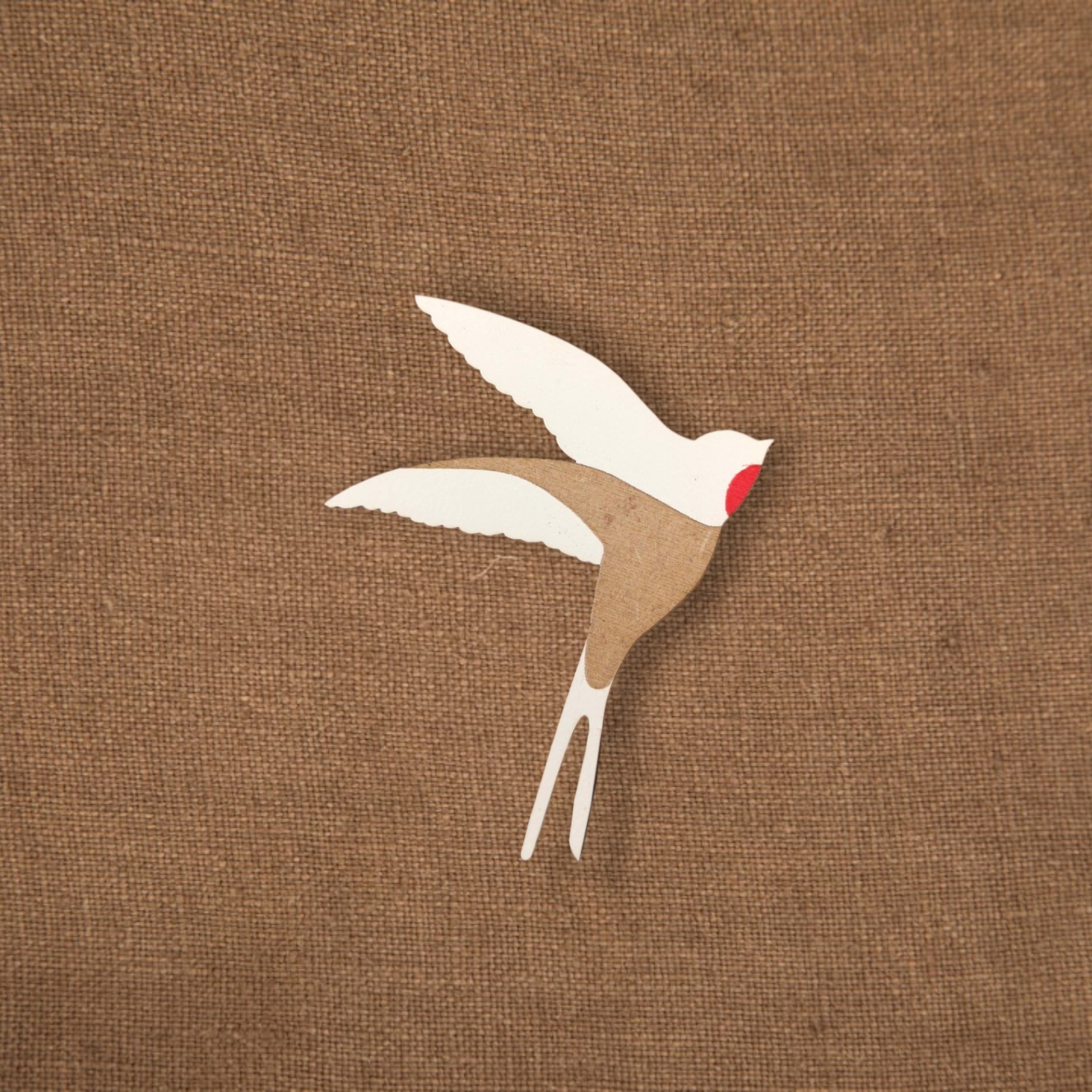 Pregadeira Andorinha Objeto decorativo em forma de pássaro em papel sobre tecido castanho