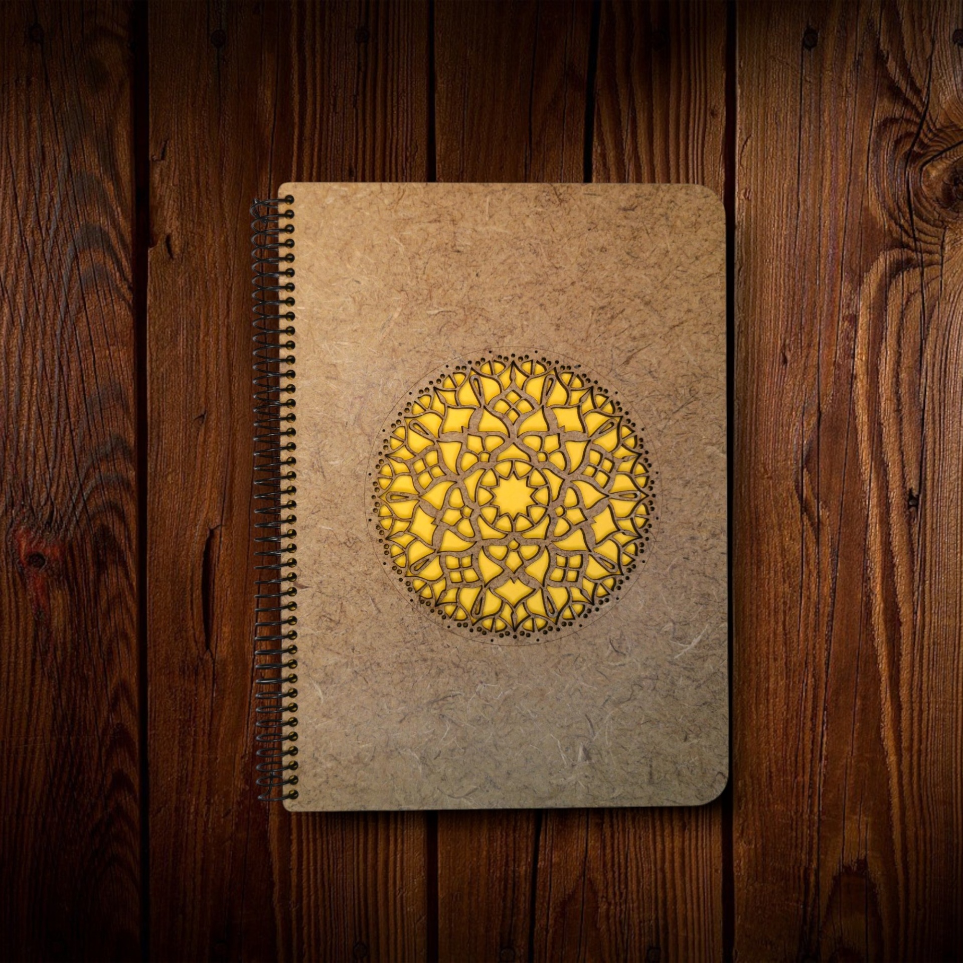 Caderno Mandala Caderno com capa castanha reciclada e padrão circular recortado amarelo sobre madeira