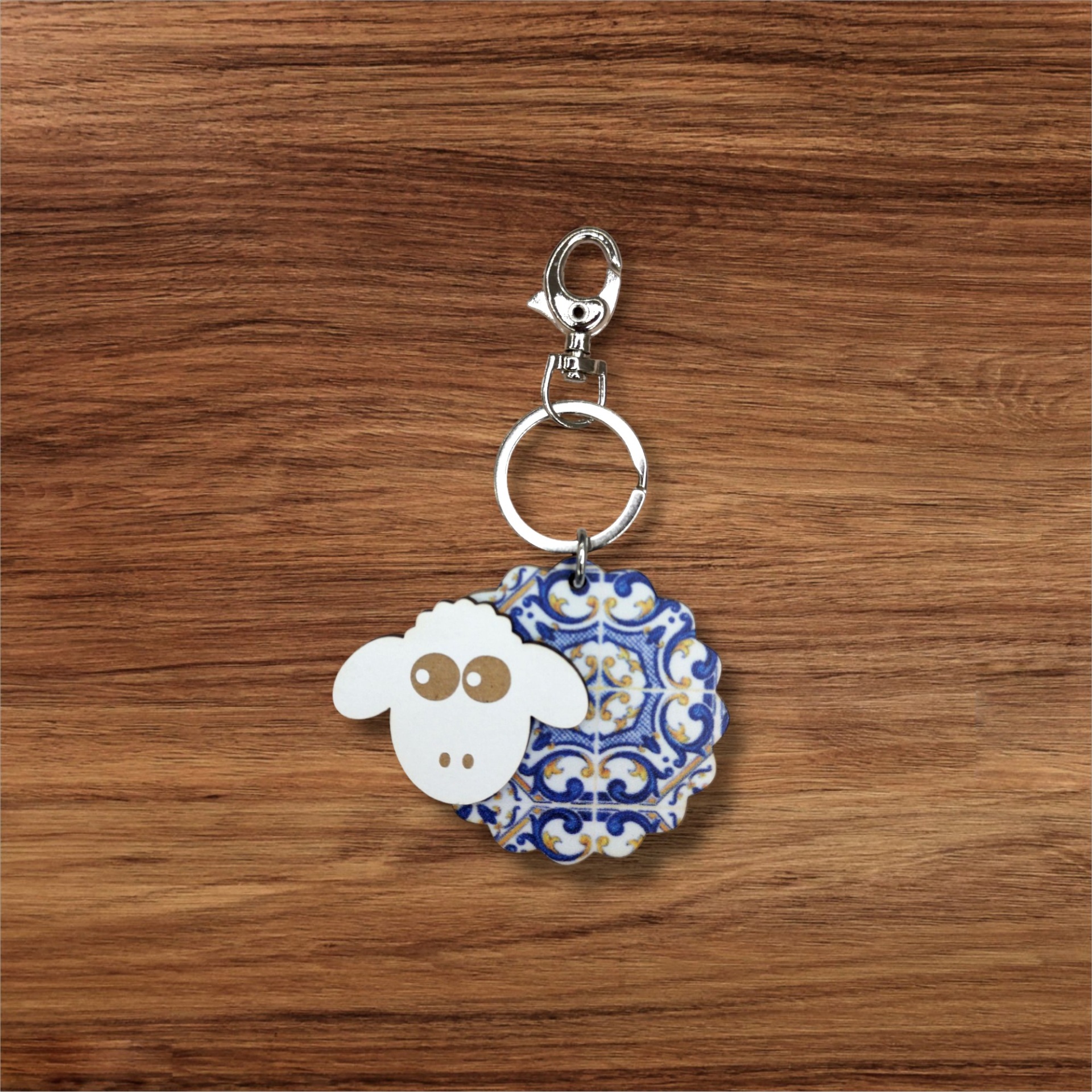 Porta-chaves Ovelhinha Porta-chaves com pendentes de ovelha branca e azulejo português em fundo de madeira.