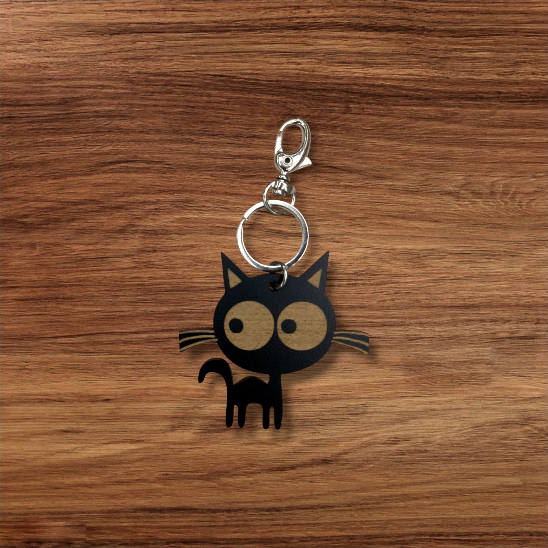 Porta-chaves Sr. Gato Porta-chaves gato preto com olhos grandes sobre fundo de madeira