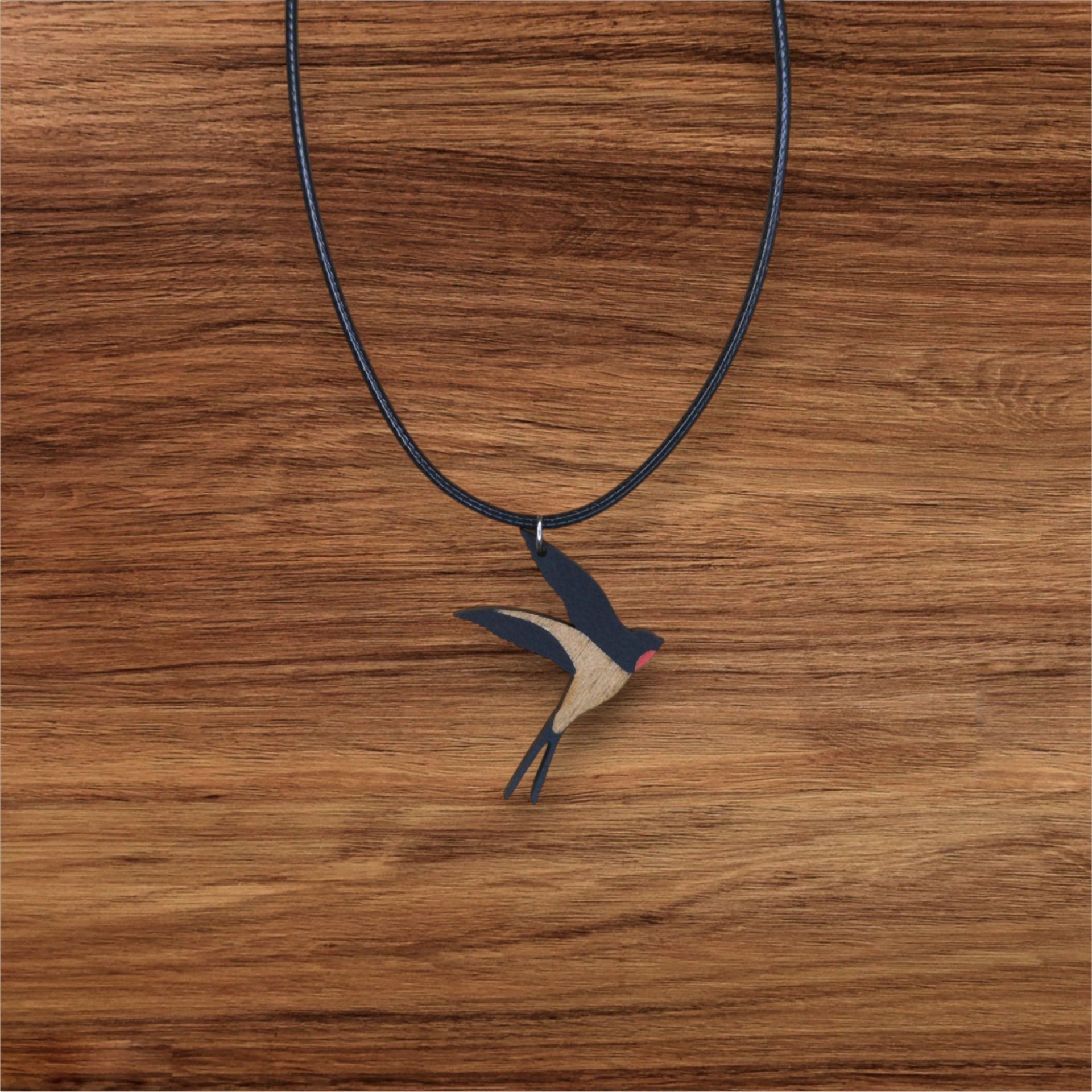 Colar Andorinha Colar com pendente em forma de pardal em madeira sobre superfície de madeira