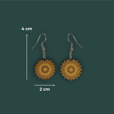 Brincos mandala dourados e castanhos com ganchos metálicos em fundo verde.