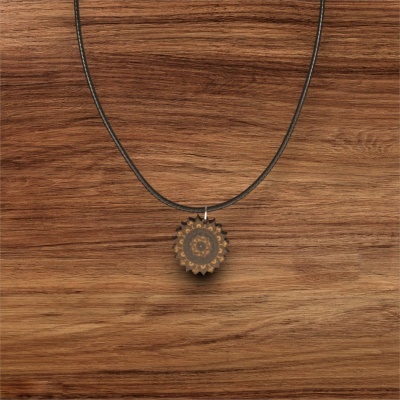 Colar com pendente redondo de madeira com padrão decorativo em fundo de madeira
