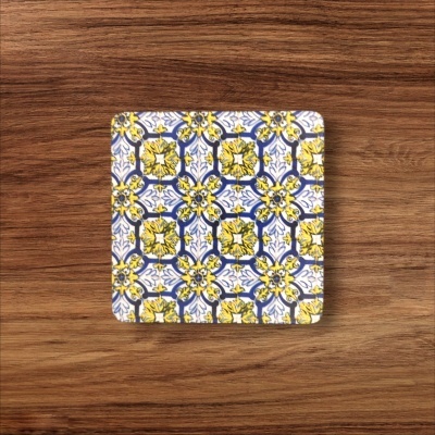 Prato quadrado em cerâmica com padrão geométrico colorido sobre mesa de madeira