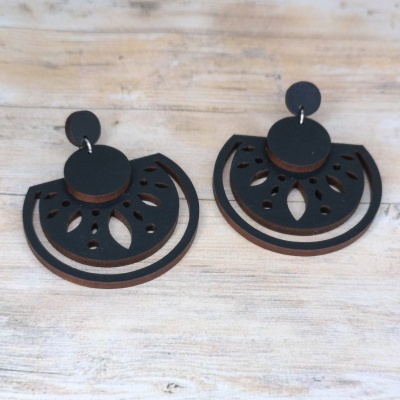 Brincos pretos em madeira com padrão recortado