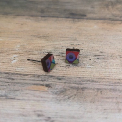 Par de brincos quadrados coloridos em madeira sobre fundo de madeira clara
