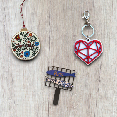 Peças decorativas de madeira e plástico com textos Amizade e Porto sobre superfície de madeira clara.