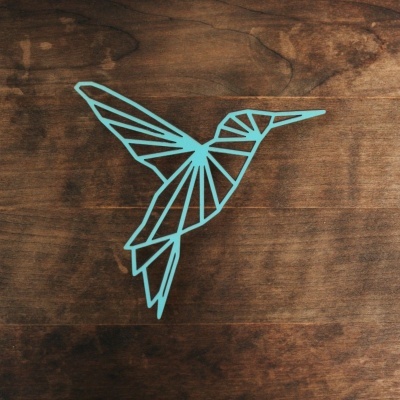 Desenho geométrico azul de um beija-flor sobre madeira marrom