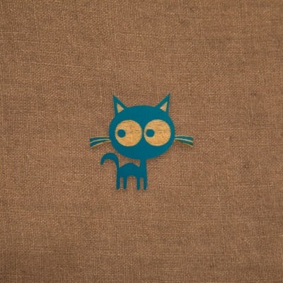 Desenho de gato azul estilizado com olhos grandes sobre fundo de tecido castanho