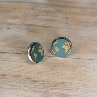 Brincos redondos com padrão do mapa mundi em azul e dourado sobre madeira